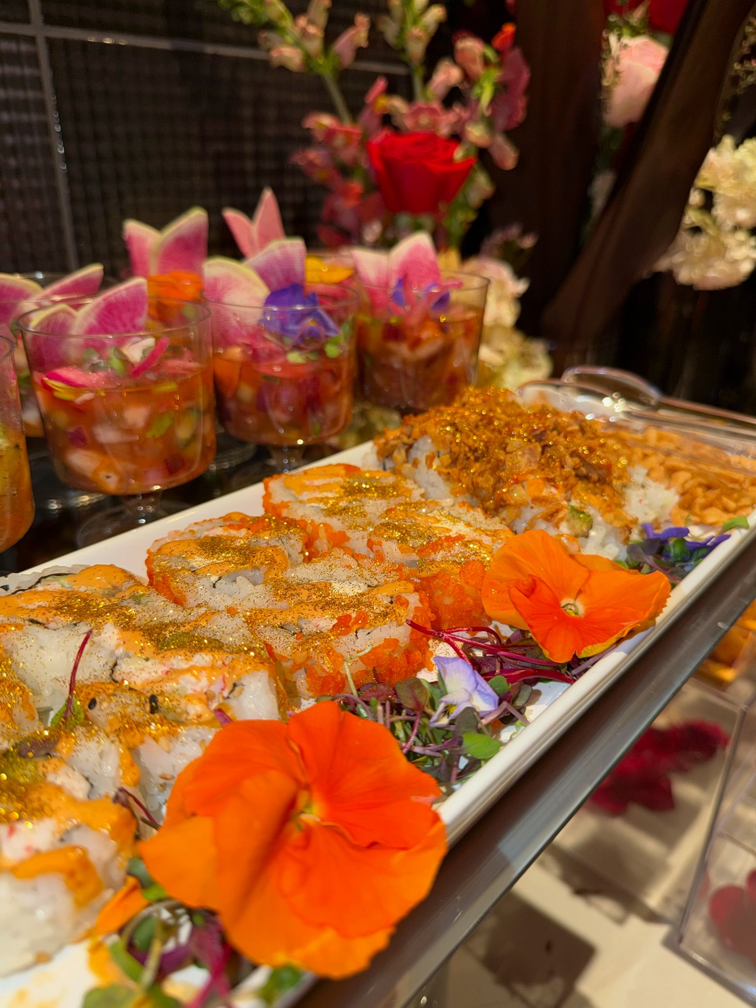 Vasitos de aguacate y salsa en capas con rábano y flores comestibles