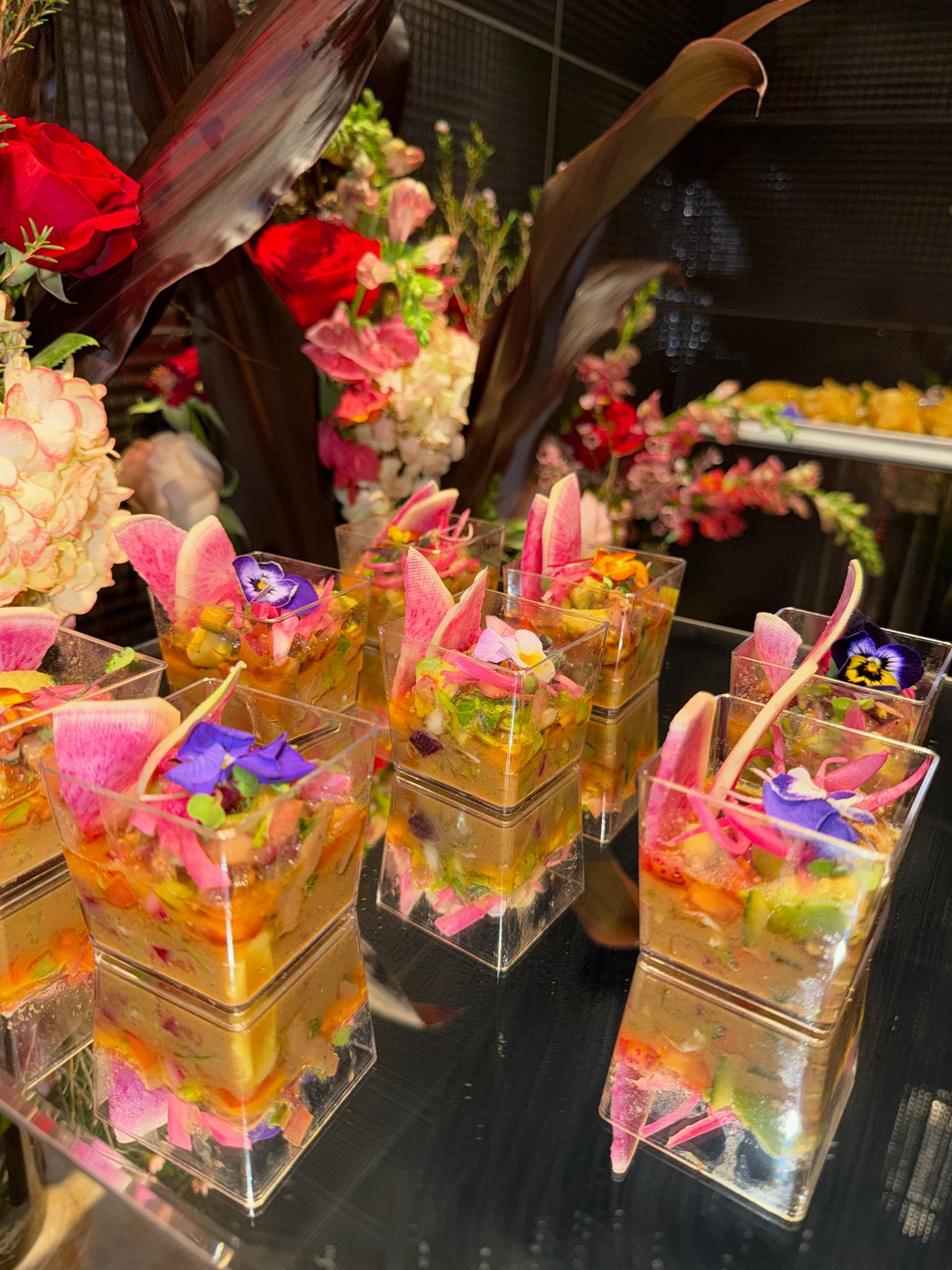 Presentación en niveles de camarones fritos y vasitos de guacamole